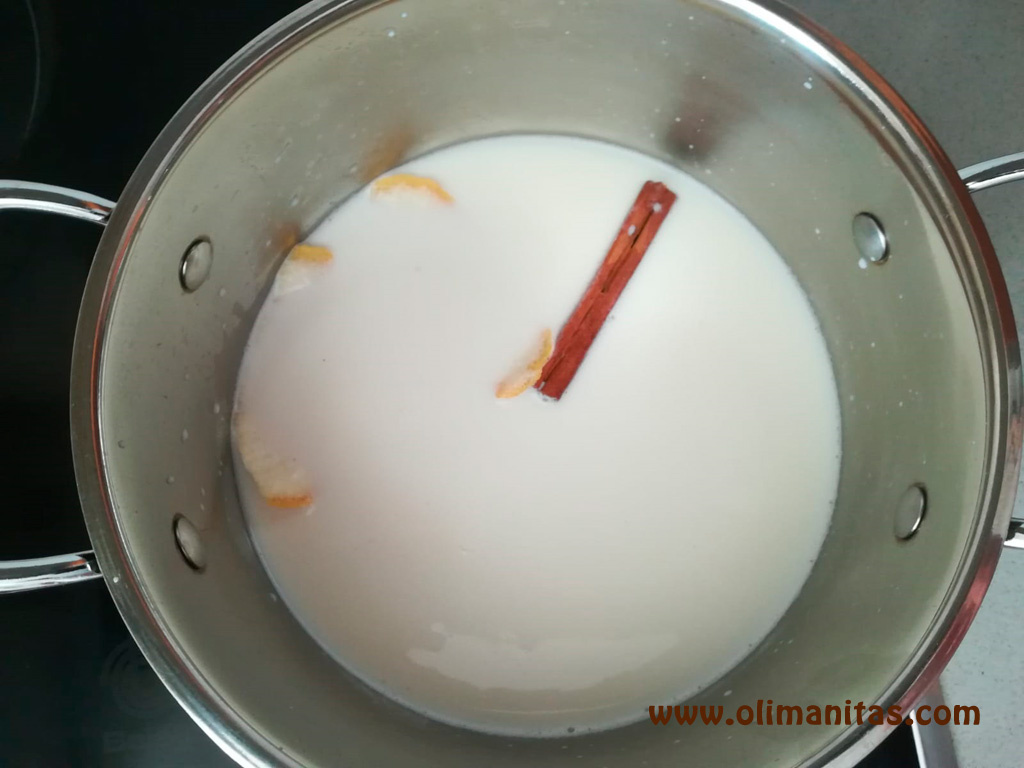 Primero calentamos la leche con el arroz, la rama de canela y las cáscaras de limón