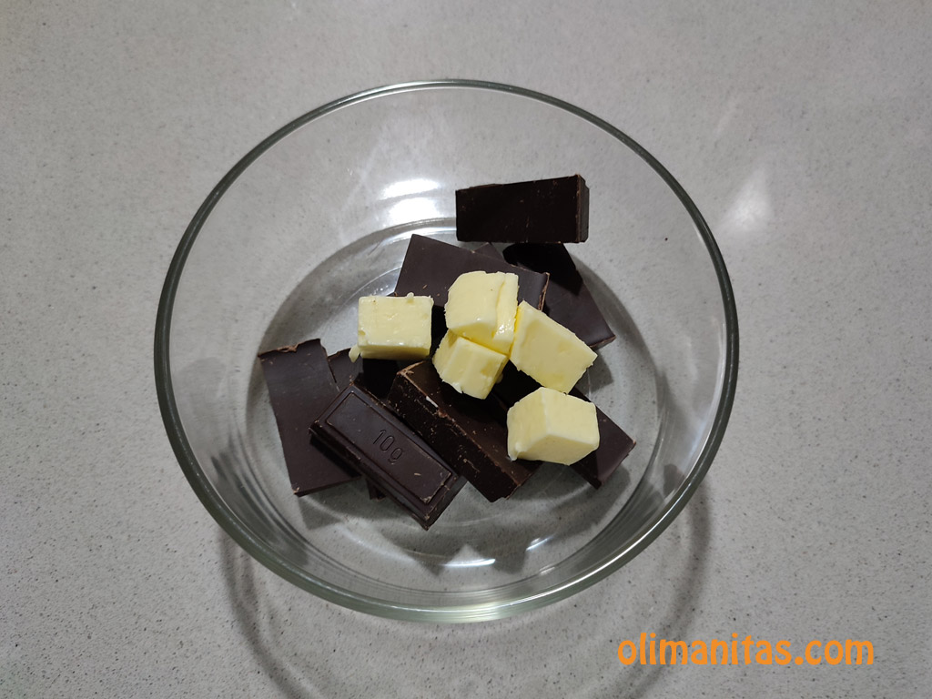 Echamos en un recipiente el chocolate de fundir y la mantequilla, con los que formaremos la cobertura de nuestras palmeritas de chocolate.