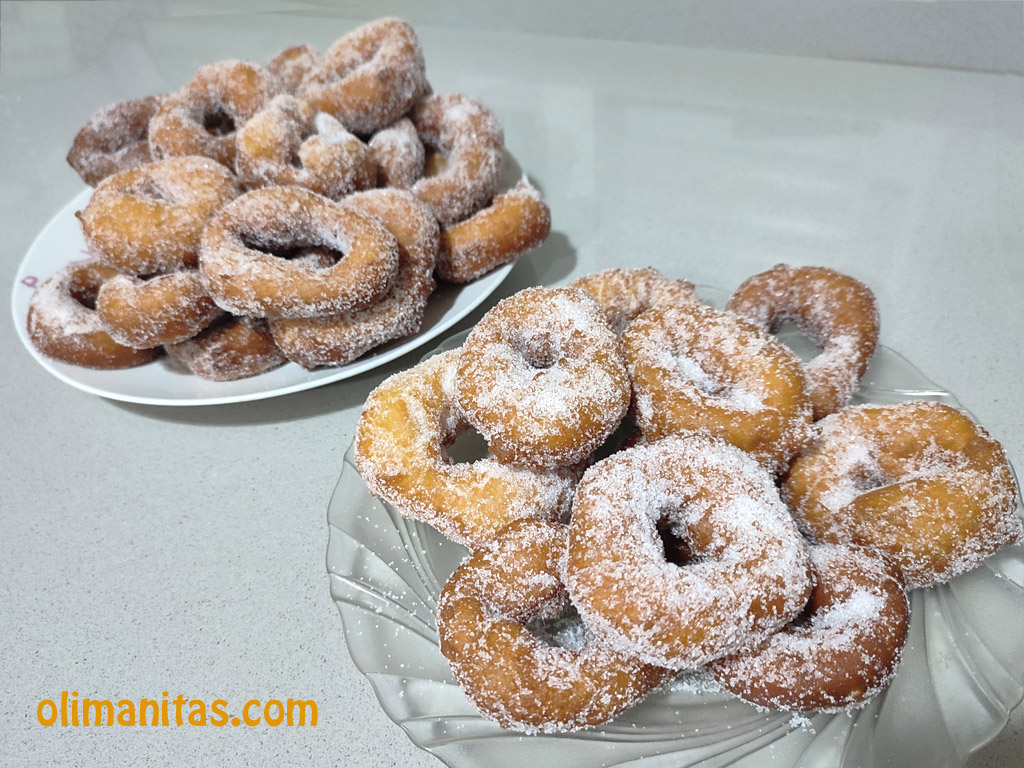 Una vez que las rosquillas fritas se atemperen un poco las rebozamos en azúcar y ya están listas para comer.