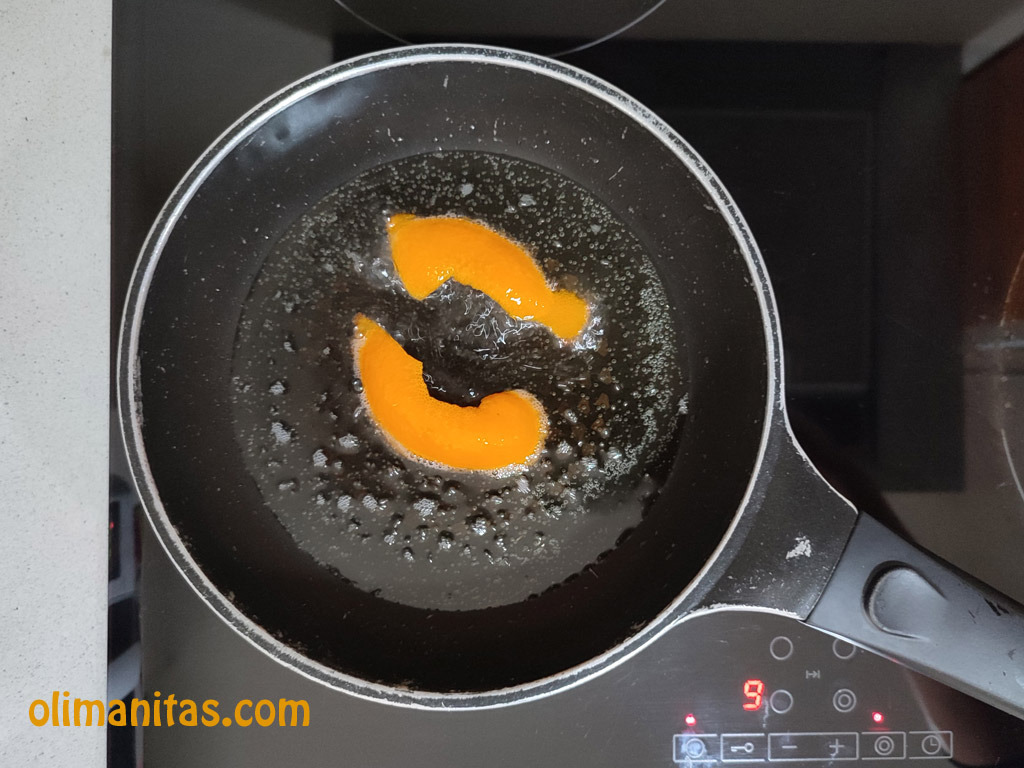 En una sartén freímos con aceite de girasol dos trozos de piel de la naranja.